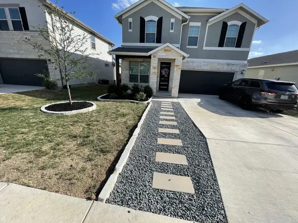 Front yard landscaping with stone walkway and mulch beds in Cibolo, TX